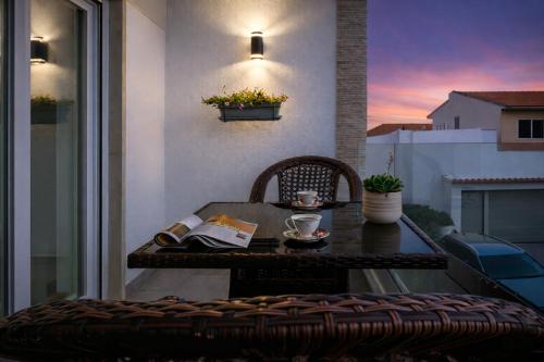 a table and chair on a balcony with a cup of coffee at Gold Coast Photography Inn Cascais in Estoril