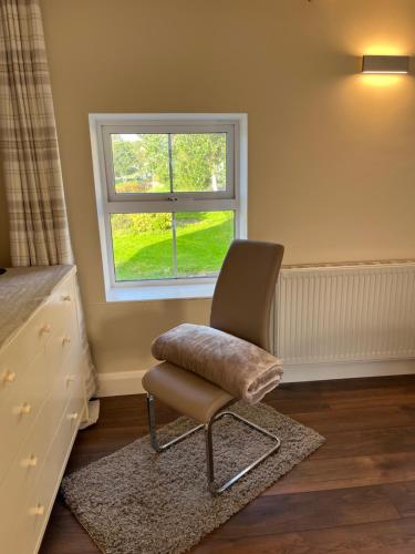 a chair sitting in a room with a window at Time Out Accommodation in Cahersiveen