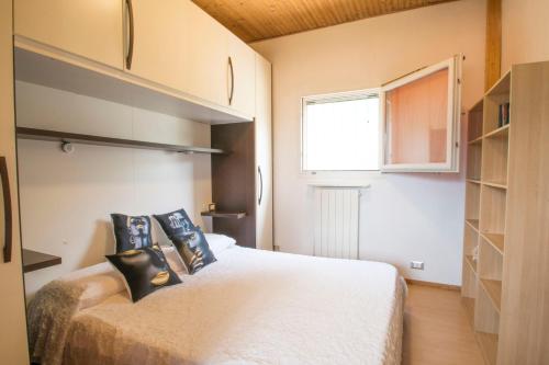 a bedroom with a white bed with black pillows at Villa Laura in Germignaga