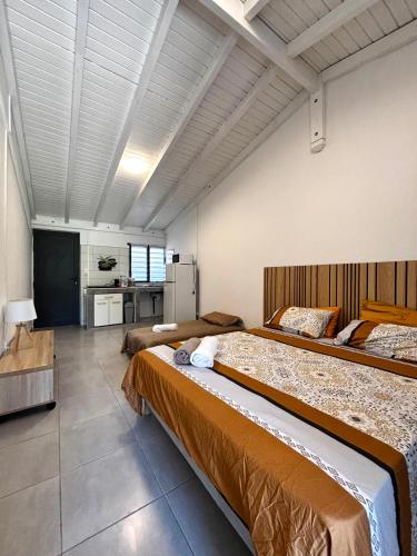 a large bedroom with two beds and a kitchen at D O M A I N E - D E - L' A N S E - P I S T O L E T - Proche Grande Vigie, Vue Unique in Anse-Bertrand