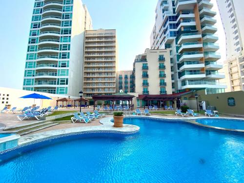a swimming pool in a city with tall buildings at Astur Hotel & Residence in Veracruz