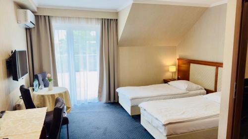 a hotel room with two beds and a window at Hotel Zajazd Polonez in Tuczempy