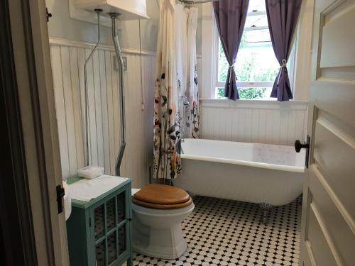 a bathroom with a tub and a toilet and a window at Midtown Vibe in Sacramento