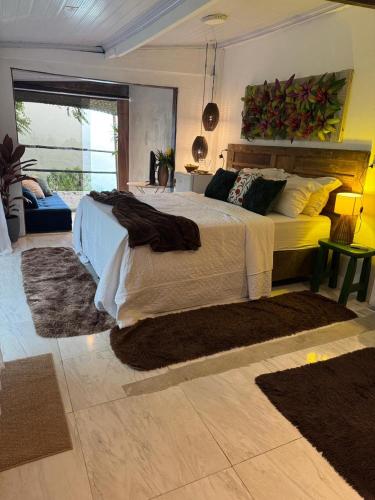 a bedroom with a large bed with rugs on it at Pousada Sonho Real in Angra dos Reis