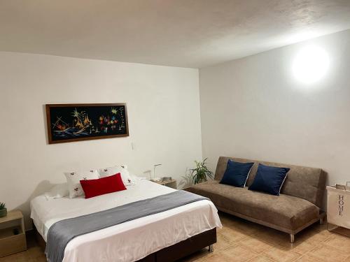 a bedroom with a bed and a couch at Casa El Pinar in Jardin