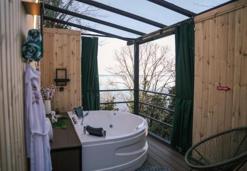 a bathroom with a tub and a large window at Luxury Glamping near Batumi in Batumi