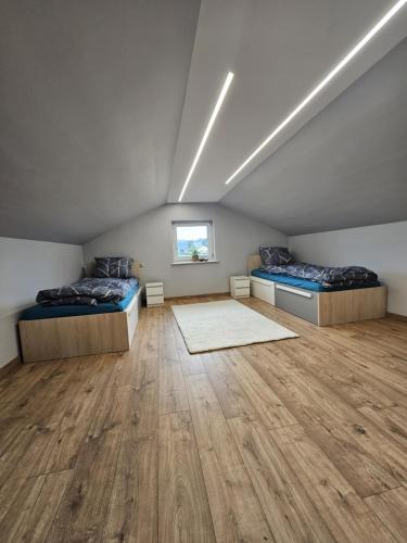 a attic room with two beds and a wooden floor at Domek na Sosnowej in Wilków