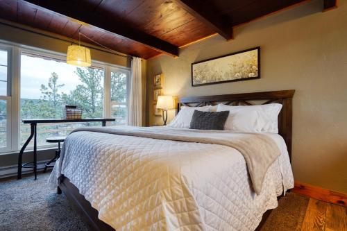 a bedroom with a bed and a table and a window at Columbine Cabin at Highland Meadows in Hot Springs
