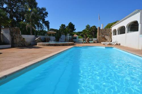 a large blue swimming pool in front of a house at Camping Via Romana in Prunelli-di-Fiumorbo