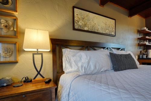 a bedroom with a bed and a lamp on a table at Columbine Cabin at Highland Meadows in Hot Springs