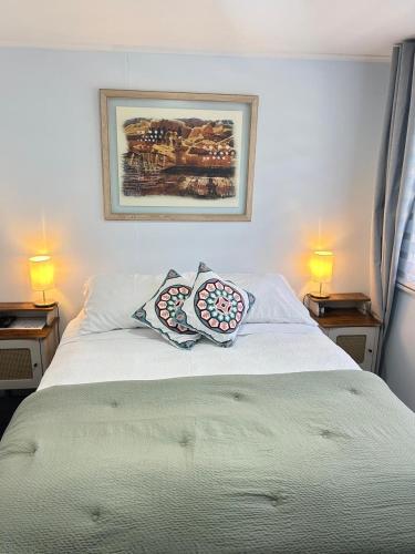 a white bed with two pillows on top of it at Hostal Like Home in Puerto Natales