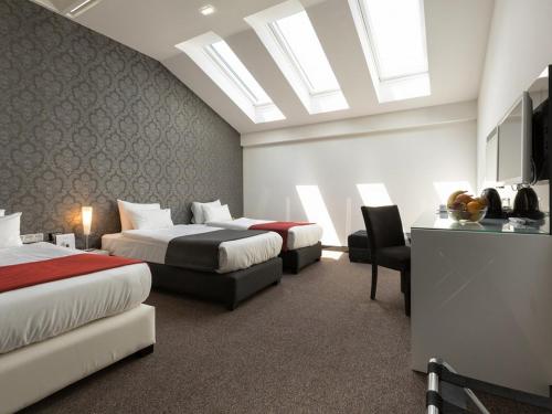a hotel room with two beds and a skylight at Nova City Garni Hotel Signature Collection in Belgrade
