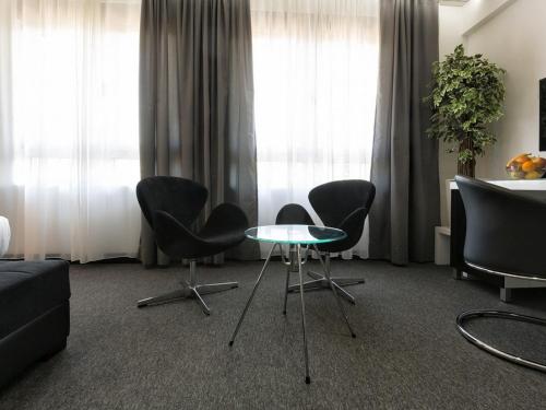 a living room with chairs and a glass table at Nova City Garni Hotel Signature Collection in Belgrade