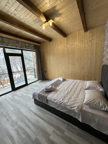 una camera da letto con un letto in una stanza con pareti in legno di Cardinal Villa a Tʼeghut