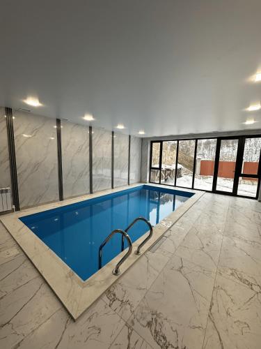 una grande piscina con acqua blu in un edificio di Cardinal Villa a Tʼeghut
