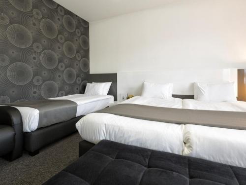 a hotel room with two beds and a couch at Nova City Garni Hotel Signature Collection in Belgrade