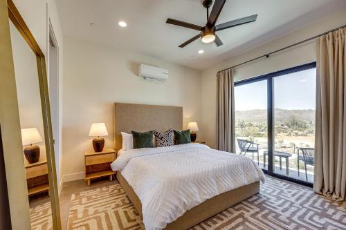 a bedroom with a bed and a large window at Luxury Desert Villa with Pool and Spa in Yucca Valley