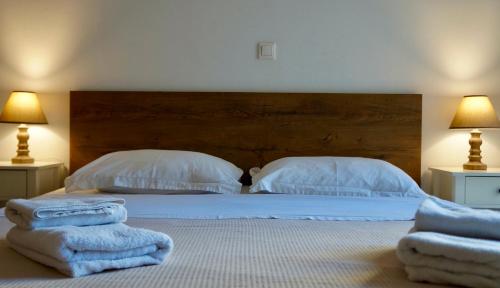 ein Schlafzimmer mit zwei Betten, weißen Kissen und Handtüchern. in der Unterkunft Central in Chalkida