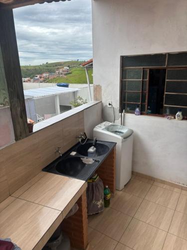 a bathroom with a sink and a toilet at Casa Central Aconchegante in Cunha