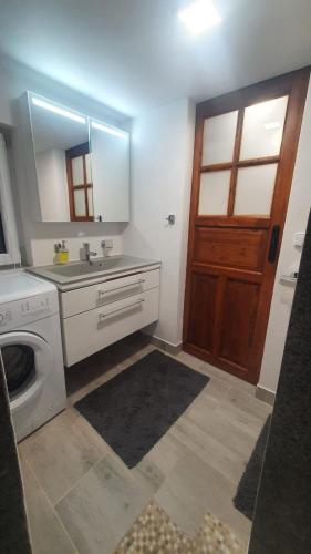 a bathroom with a sink and a washing machine at U Studánky in Drnovec