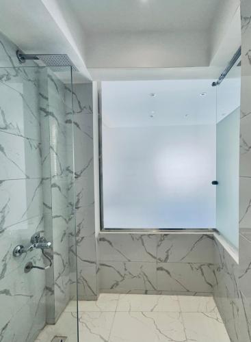 a shower with a glass door in a bathroom at Atlantis pirámides view Inn in Cairo