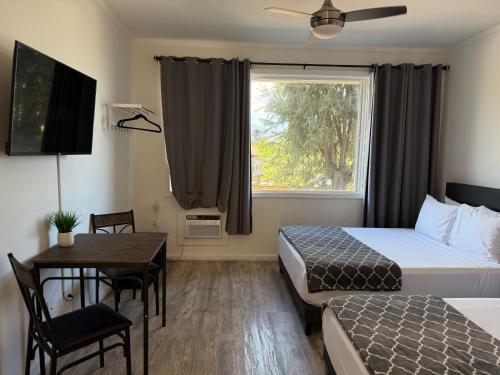 a hotel room with two beds and a table and a window at Unit 9 Waena Inn Newly Renovated Maui Private Suite in Wailuku