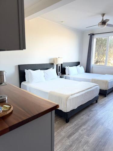 a bedroom with two beds and a kitchen with a table at Unit 10 Waena Inn - Maui Private Suite in Wailuku
