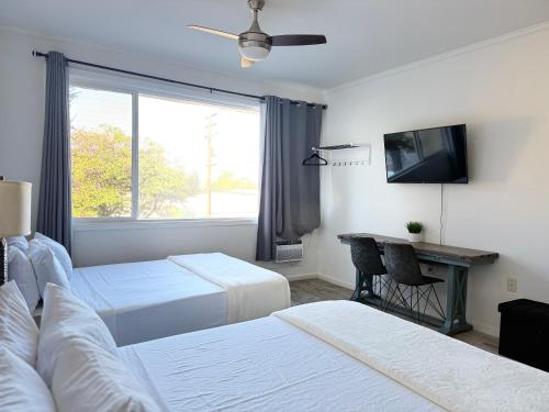 a hotel room with two beds and a television at Unit 10 Waena Inn - Maui Private Suite in Wailuku