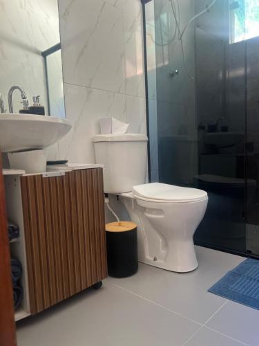 a bathroom with a toilet and a sink and a shower at Casa do Bosque in Paty do Alferes