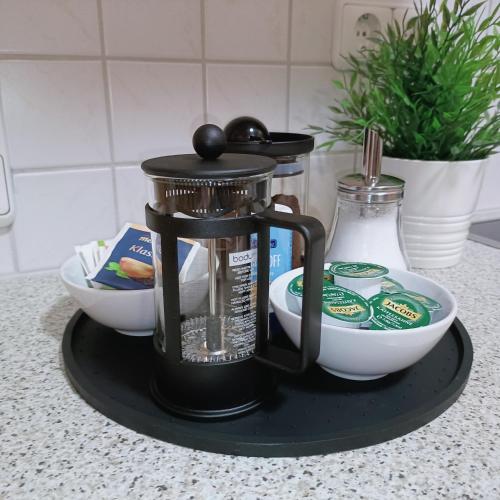 a coffee maker and bowls on a tray on a counter at TauberNest in Bad Mergentheim