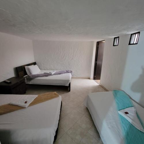a hotel room with two beds and a chair at Viviendas Turísticas in Jericó