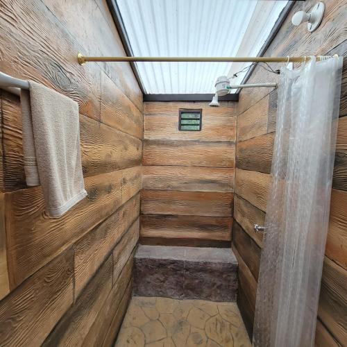 a bathroom with wooden walls and a shower at Viviendas Turísticas in Jericó