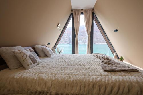 a bedroom with a large bed with a large window at "Vista Frame" JAZ - lake view in Višegrad