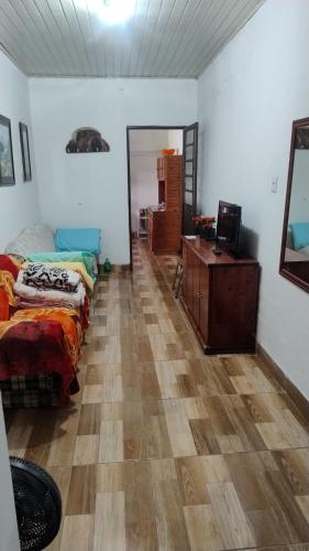 a room with two beds and a dresser and a mirror at Pousada da bancários in São Gabriel