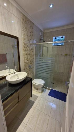 a bathroom with a sink and a toilet and a shower at Loft 150m da praia in Itajaí