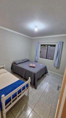 a bedroom with two beds and a window at Loft 150m da praia in Itajaí