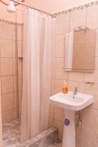 a bathroom with a sink and a shower with a shower curtain at Hotel Posada Stella Maris in Puerto Barrios