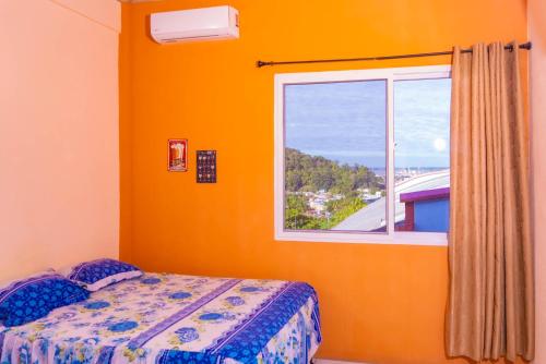 a bedroom with a bed and a window at Hotel Posada Stella Maris in Puerto Barrios