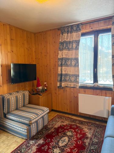 a living room with a couch and a flat screen tv at Chalet Nonno Ezio in Valdidentro