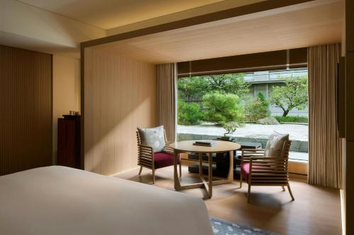 a hotel room with a bed and a table and chairs at The Ritz-Carlton Kyoto in Kyoto
