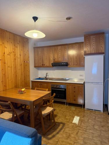 a kitchen with a wooden table and a refrigerator at Chalet Nonno Ezio in Valdidentro