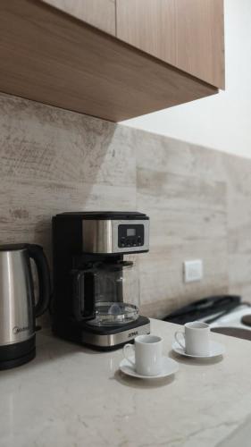 a kitchen counter with two cups and a coffee maker at Duplex Atenea in Chivilcoy