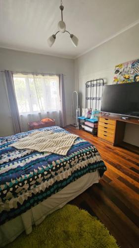 a bedroom with a bed and a desk and a fan at Hostel Varas in Viña del Mar