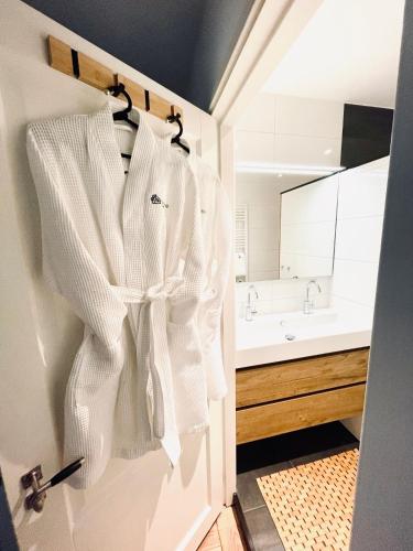 a white robe hanging on a door in a bathroom at Gorgeous And Stylish Place For Two In Hip West! in Amsterdam