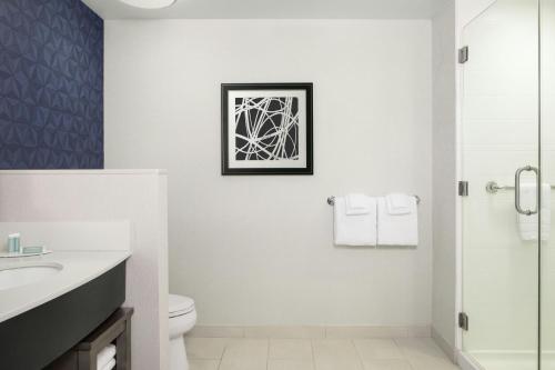 a bathroom with a sink toilet and a picture on the wall at Courtyard by Marriott Wilmington Downtown/Historic District in Wilmington