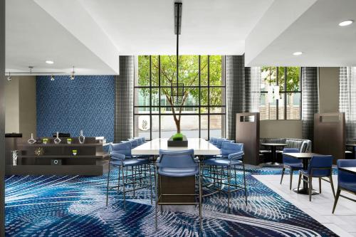 a dining room with a table and blue chairs at Courtyard by Marriott Wilmington Downtown/Historic District in Wilmington
