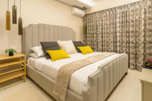 a bedroom with a large white bed with yellow pillows at Confortable Apartamento Centro Ciudad in Santo Domingo