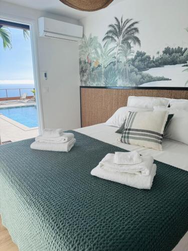 a bedroom with a bed with towels on it at Villa Ô in Les Avirons