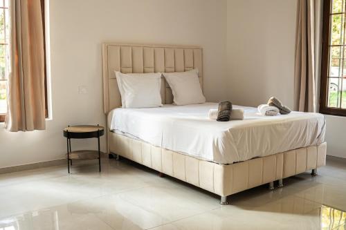 a bedroom with a large bed with shoes on it at Domaine de la batelle in Arles