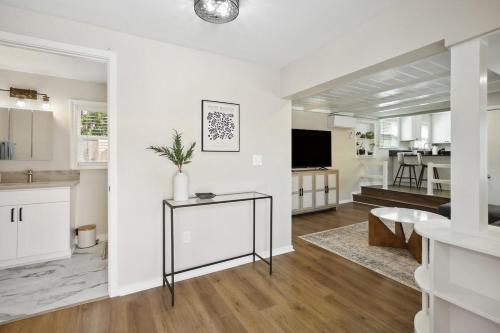 a white living room with a table and a tv at Pet-Friendly Private Cottage In Tahoe Park in Sacramento